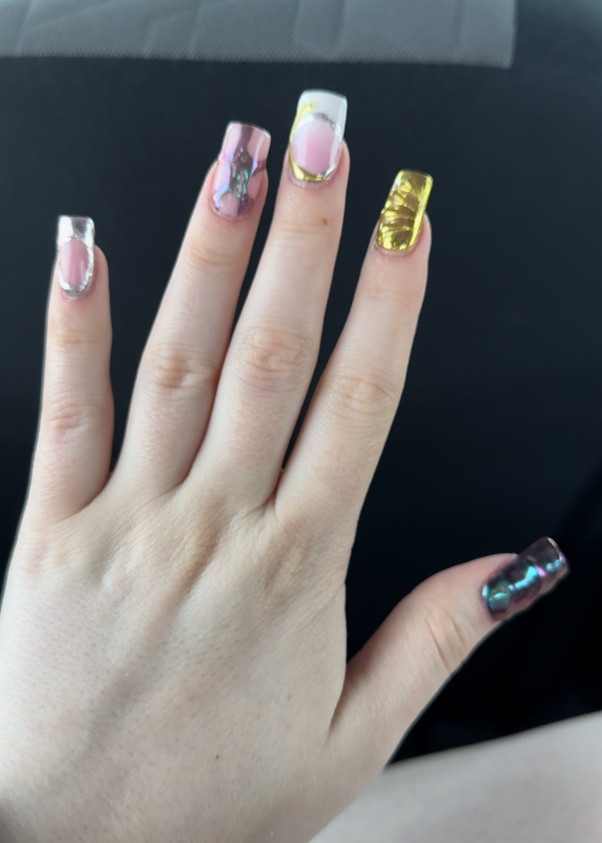 Hand with painted nails against a black and blue background